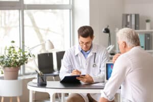 Older man meeting with urologist to discuss PAE